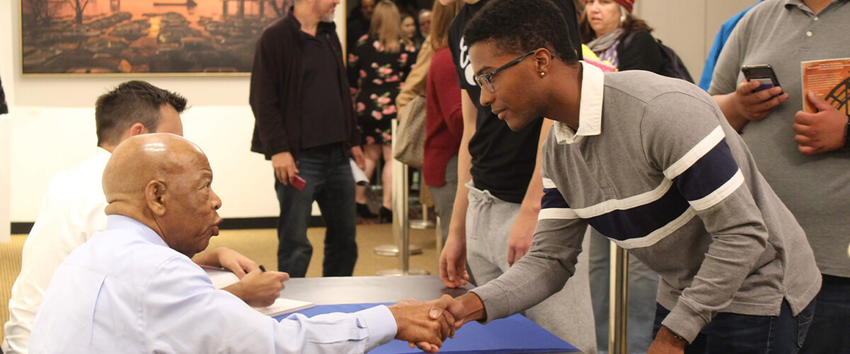 Two men shaking hands during Vermont Reads signing